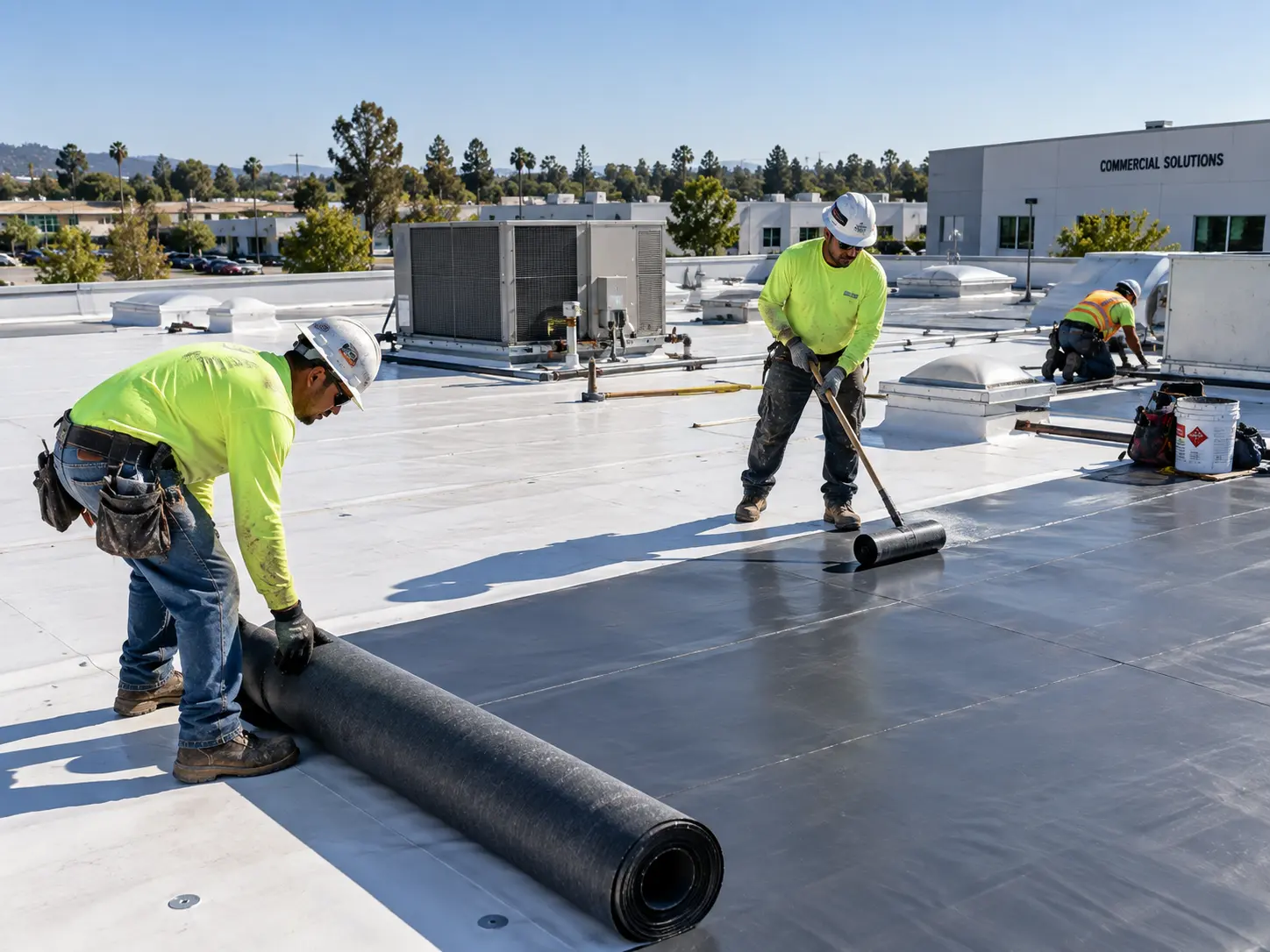 Roofers working on a commercial flat roofing system